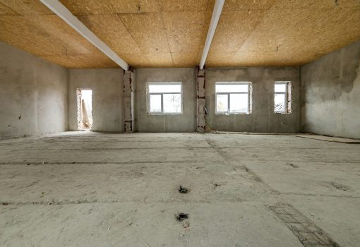 Unfinished apartment or house big loft room under reconstruction. Plywood ceiling, plastered walls